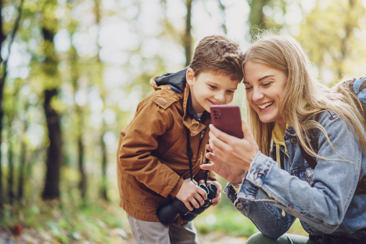 Mor og son ser på telefon.