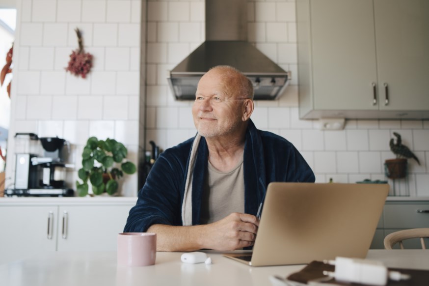 Mann foran PC som ser fornøyd ut.
